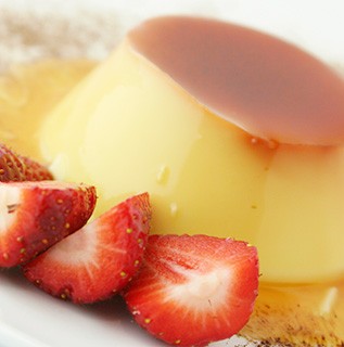 Mexican Traditional Flan dessert with carmel and strawberry sauce
